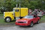 Bright red Chevy Monte Carlo SS alongside Peterbilt